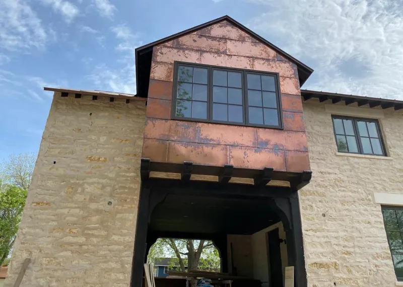 Copper metal panel facade on a stone building for Roof Repair in Summit
